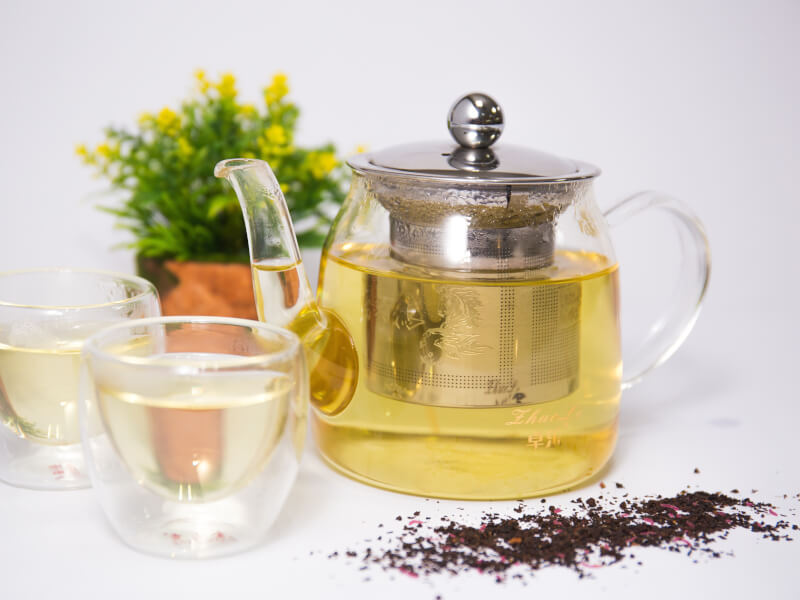 Two cups of tea and a glass teapot ready for tea tasting at home.